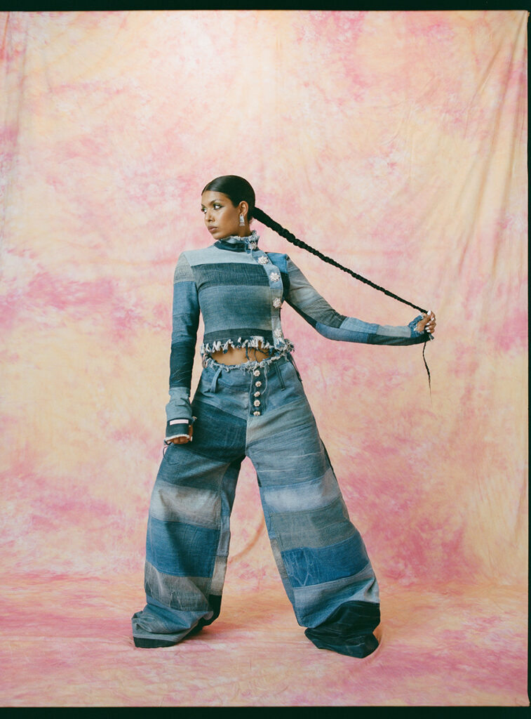 Pia Ahmed aus Bangladesch in einem Jeans-Zweiteiler hält ihren langen geflochtenen Zopf von sich weg.